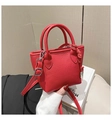 Vue détaillée du mini sac carré rouge texturé avec boucles argentées et nœud latéral - Rouge