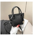 Gros plan du sac seau noir en cuir grainé avec breloque cœur argentée et bandoulière - Noir