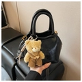 Detail of black textured leather shoulder bag with gold hardware and yellow teddy bear charm - Black with Pendant