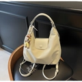 Cremeweiße Hobo-Tasche aus weichem Kunstleder mit Puppenanhänger und Perlenkette - Beige mit Anhänger