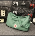 Detailansicht der dunkelgrünen Nylon-Tragetasche mit Logo und verstärktem schwarzen Boden - Grün