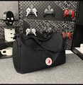 Detail der schwarzen Nylontasche mit Seitenreißverschluss und Logo-Aufnäher - Schwarz