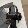 Glossy black bowling bag with silver hardware for women in a lifestyle hand-held view - Black without Pendant