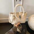 Minimalistische beige bucket bag van leer met handvatten en zilveren metalen sluiting - Wit