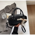 Detail einer schwarzen Webmuster-Handtasche mit silbernen Beschlägen und Spitzenbogen - Mit Anhänger / Schwarz