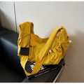 Detail van gembergele nylon crossbodytas met trekkoordsluiting en matzwarte gesp - Geel