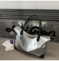 Détail du sac cabas argenté en PU, texture froissée, finitions en cuir noir et fermeture éclair - Argenté