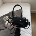 Elegante zwarte glanzende Boston-tas met parelmoeren strikhanger en verstelbare riem - Zwart met hanger