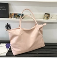 Gros plan d'un grand sac cabas rose pâle en cuir grainé avec fermeture éclair durable - Rose