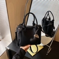 Elegante borsa a secchiello nera con trama litchi, doppi manici e ciondolo cuore - Nero
