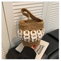 Detail of hand-woven brown straw bucket bag with white circular charms and single handle - Brown