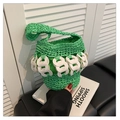 Close-up of green hand-woven straw bucket bag with white circular link decorative chain - Green