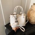White lychee grain bucket bag with unique knotted handle and heart-shaped pendant - White
