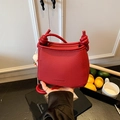 Fashionable red lychee textured bucket bag with a cute white bunny charm - Red
