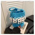 Close-up of blue woven bucket bag with white chain details and braided handle - Blue