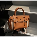 Close-up of contrast leather bucket bag with geometric cutout and canvas detail - Brown