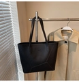 Dettaglio della grande borsa tote nera minimalista con pelle a grana di litchi - Nero