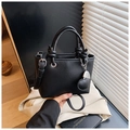 Elegant black lychee grain leather bucket bag with top handle and heart-shaped charm - Black