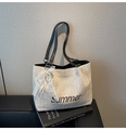 Detail of straw tote bag featuring Summer embroidery and a lace pearl bow charm - Black with Pendant