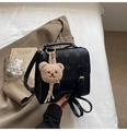 Detail of a structured black leather backpack featuring gold buckles and a cute teddy charm - Black With Pendant