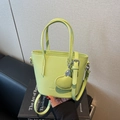 Lime green leather bucket bag with top handles, crossbody strap and heart charm - Green
