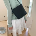 Sac seau bandoulière en cuir noir minimaliste avec texture grainée sur tenue décontractée - Noir Avec Pendentif