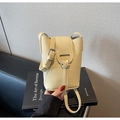 Detailed view of pale yellow lychee pattern leather texture and silver buckle on crossbody bag - Yellow