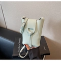 Detail of light green pebbled leather mini bucket bag with leather knot and silver buckle - Light Green