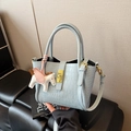 Hellblaue Eimerhandtasche mit Krokodilprägung, goldenem Schloss und Pferdeanhänger - Blau mit Anhänger