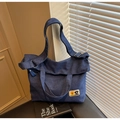 Macro detail of dark blue denim tote bag featuring floral patches and silver hardware - Dark Blue