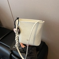 White bucket bag with woven strap, textured surface, and heart-shaped pendant accessory - White