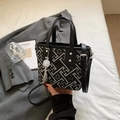 Detailed view of embroidery bucket bag with grey geometric patterns and elegant tassel - Black