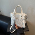 Beige bucket bag with geometric jacquard pattern, grey tassels, and top handle strap - Off White