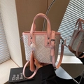 Pink leather trim bucket bag with geometric prints and tassel charm on a hand - Pink