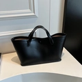 Sac fourre-tout noir minimaliste en cuir avec fermeture bouton sur support blanc - Noir
