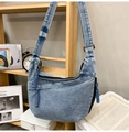 Detail of blue washed denim crossbody bag with woven rope zipper pulls on wood shelf - Vintage Blue