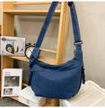 Detailed view of the denim hobo bag featuring a knotted zipper pull and adjustable strap - Dark Blue