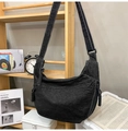 Detail of black denim hobo bag showing adjustable strap and white contrast stitching - Black