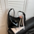Glossy black hobo shoulder bag with pink heart charm and lace ribbon on leather sofa - Black with Pendant