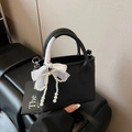 Black bucket bag with pearl bow pendant and white silk-wrapped handle detail - With Charm / Black