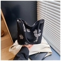 Minimalist black canvas tote bag featuring large white floral prints and handle detail - Black