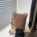 Brown hand-woven bucket bag with floral crochet pattern and decorative side tassels - Khaki