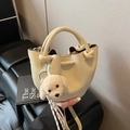 Creamy beige pebbled leather bucket bag with knotted handle and plush puppy charm - With Charm / Yellow