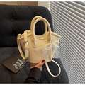Creamy white leather bucket bag featuring elegant pearl and lace bow charm detail - With Pearl Lace Bow Charm / Off White