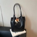 Grande borsa tote in pelle intrecciata nera con ciondolo a cavallo su sfondo grigio - Nero con ciondolo