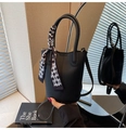 Detail of black bucket bag with lychee pattern leather and checkered silk scarf handle - Black