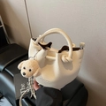 Creamy white lychee leather bucket bag with puppy charm and round ring handles - With Charm / Off White