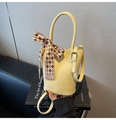 Detail of yellow lychee leather bucket bag with decorative scarf and metal buckle - Yellow