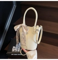 Chic beige bucket bag with lychee texture and decorative silk scarf on handle - White