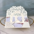 Detail of laser-cut 3D wedding invitation with rose hollow patterns and silhouette - Ivory